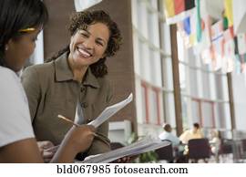 Teacher giving paperwork to student