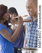 African man tasting tomato sauce