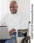 African man in wheelchair using laptop
