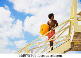 African man holding body board on lifeguard hut ramp