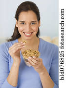 mulher hispânica, comer, nozes