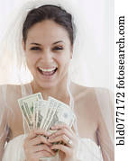 Bride holding handful of money