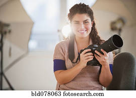 Mixed race woman holding camera