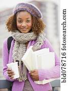 Mixed race woman holding books and drinking coffee Mixed race woman holding books and drinking coffee