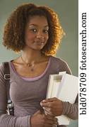 Mixed race woman holding books