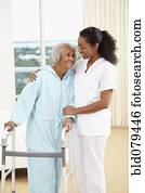 African American nurse helping senior woman with walker