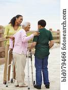 African American woman using walker with help of family