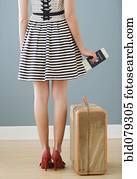 Mixed race woman with passport and suitcase