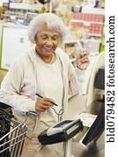 Senior African American woman paying with credit card in grocery store