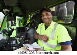 African American man driving garbage truck