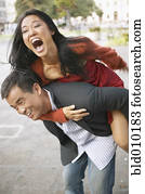 Woman riding piggyback on a young man