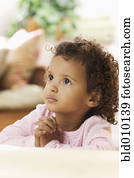 Young African American girl praying at bedside