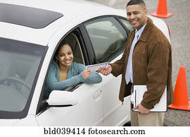 African teenager receiving drivers test certificate