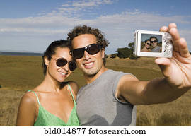 Couple taking self-portrait with camera