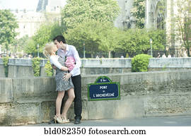 Caucasian couple kissing on Pont de L'Archeveche
