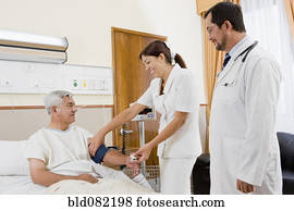 Doctor and nurse examining patient in hospital room