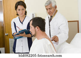 Doctor and nurse examining patient in hospital room