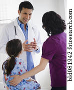 Doctor talking to mother and daughter in examination room