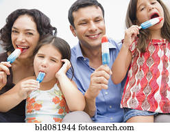 Smiling family eating popsicles together
