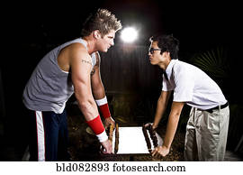 Geek and body builder playing chess