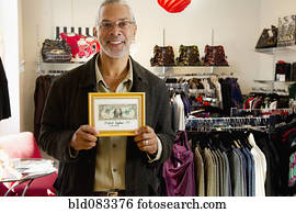 African American small business owner holding first dollar