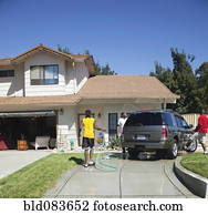 Black family washing car in driveway