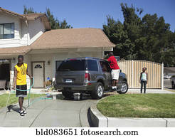 Black family washing car in driveway