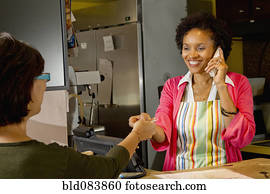 African American bakery owner taking customer's credit card