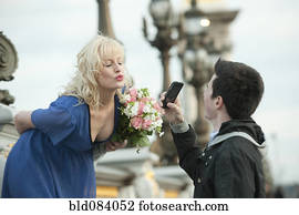 Caucasian man photographing girlfriend