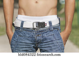 Bare chested Hispanic man with hands in pockets