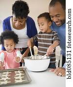 Black family baking cookies together