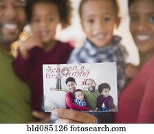 Black family holding Seasonís Greetings photograph