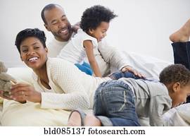 Black family laying on bed together