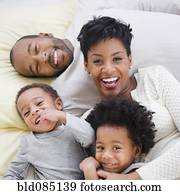 Black family laying on bed together