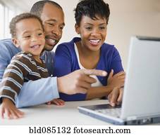 Black family using laptop together