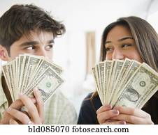 Couple holding handfuls of money