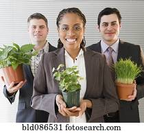 Business people holding potted plants
