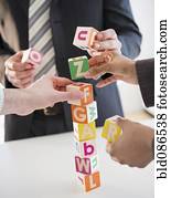 Business people stacking alphabet blocks
