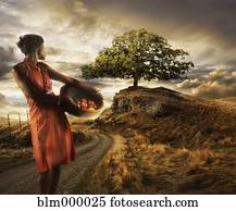 African woman holding basket of fruit