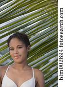 Hispanic woman standing near palm leaf