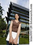 Mixed race woman holding laptop on campus outdoors Mixed race woman holding laptop on campus outdoors