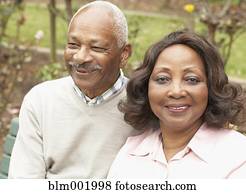 Senior African couple hugging and smiling outdoors