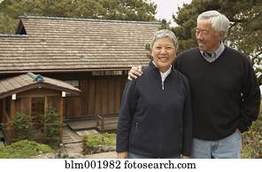 Senior Asian couple smiling and hugging outdoors