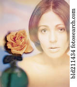 Digital composite of woman's face and rose