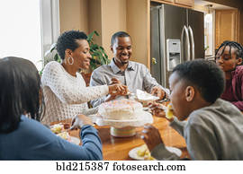 Black family eating cake at birthday party
