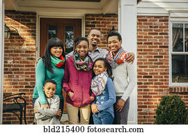 Black family smiling outside house