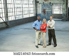Business people smiling in empty warehouse