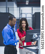 Business people using computer in server room