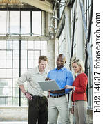 Business people using laptop in warehouse