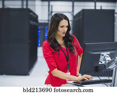 Caucasian businesswoman using computer in server room